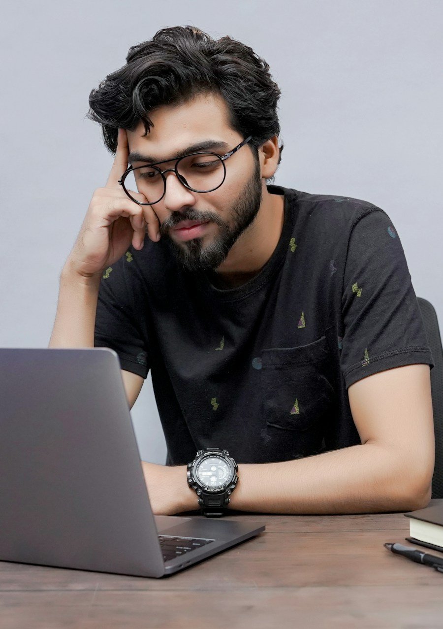 Student with glasses studying at his laptop